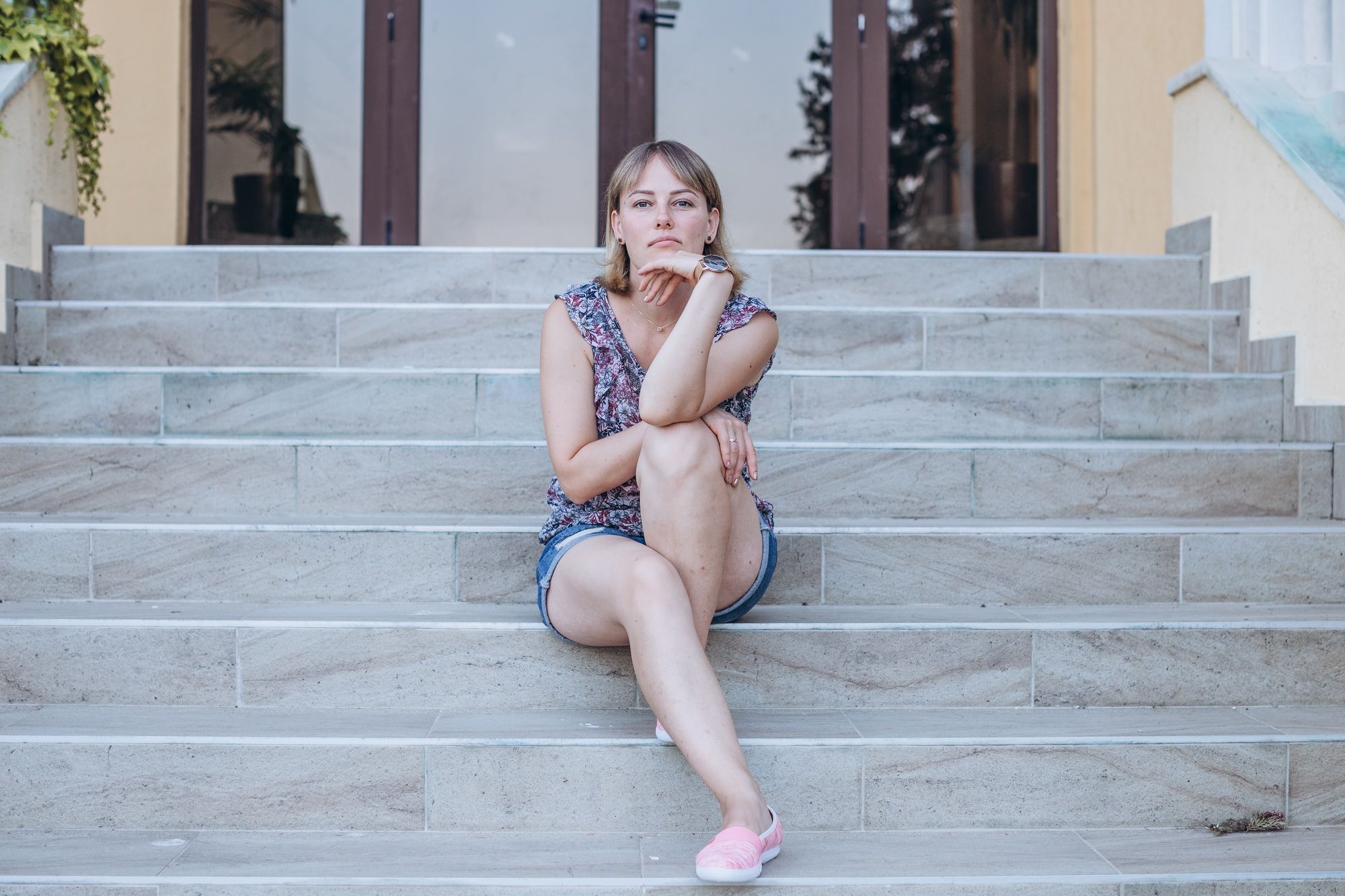Young beautiful girl posing for foto on the stairs in summer